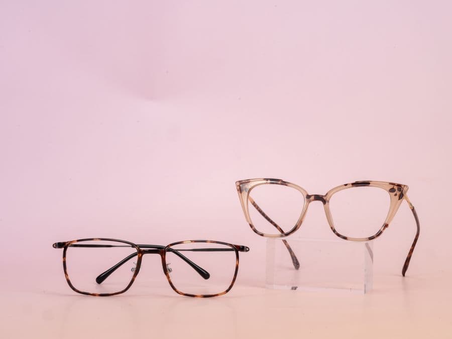 Sleek rectangular sunglasses styled on a soft pink background