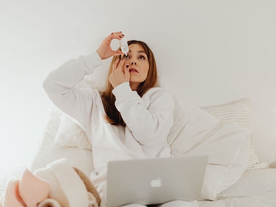 Person applying soothing eye drops at home during dry eye testing